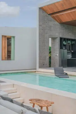 a swimming pool with a wooden bench next to a building at Villa Boya - 6BR luxury oasis in Central Berawa in Canggu
