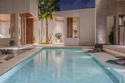 a swimming pool in a living room with a house at Villa Boya - 6BR luxury oasis in Central Berawa in Canggu
