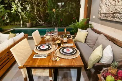 a wooden table with plates and wine glasses on a couch at 2BR Villa Violetta - Minggu Villas - Special Stay Bonus in Kerobokan