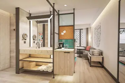 a bathroom with a sink and a living room at Aloft Bali Kuta at Beachwalk in Kuta
