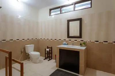 a bathroom with a toilet and a sink and a mirror at Villa Penny, Seminyak - Spacious 3 Bedroom Pool Villa! in Seminyak