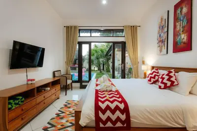 a bedroom with a large bed and a television at Villa Penny, Seminyak - Spacious 3 Bedroom Pool Villa! in Seminyak