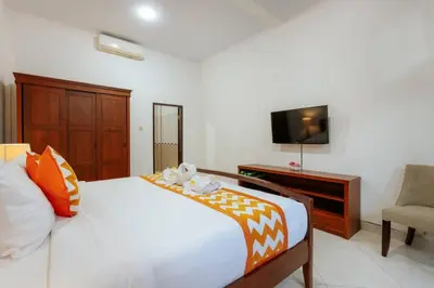 a bedroom with a bed and a tv and a chair at Villa Penny, Seminyak - Spacious 3 Bedroom Pool Villa! in Seminyak
