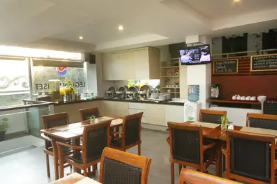 a restaurant with tables and chairs and a kitchen at The Legian Sunset Residence in Seminyak
