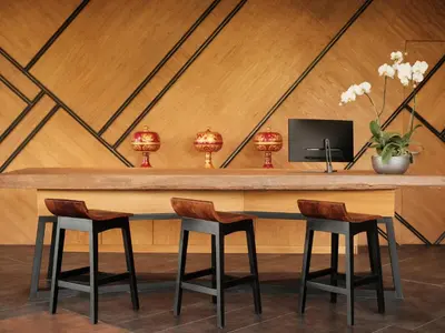 a wooden table with two chairs and a tv at Kayumas Seminyak Resort in Seminyak