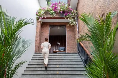a woman walking up the stairs of a building at Kayumas Seminyak Resort in Seminyak