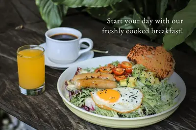 a plate of food with eggs and a sandwich and a cup of coffee at Grandmas Plus Hotel Airport in Kuta