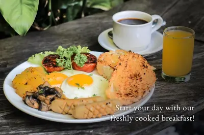 a plate of food with eggs and vegetables and a cup of coffee at Grandmas Plus Hotel Airport in Kuta