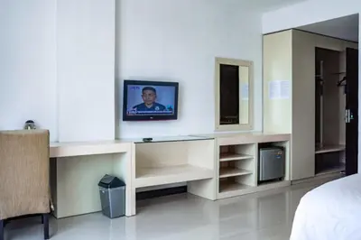 a bedroom with a bed and a tv on a wall at KoolKost at Bypass Jimbaran - Minimum Stay 30 Nights in Kuta