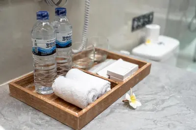 a tray with towels and bottles of water on a counter at The Eight Villa & Rooms Bali - Seminyak in Seminyak