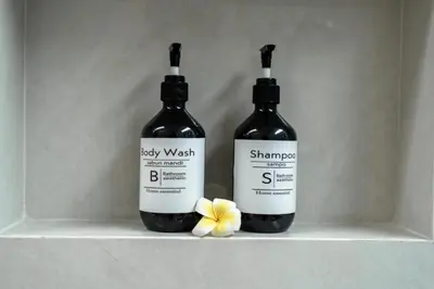 two bottles of wine sitting on a shelf with a flower at The Eight Villa & Rooms Bali - Seminyak in Seminyak