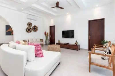 a living room with a white couch and a tv at Villa Besakih in Canggu