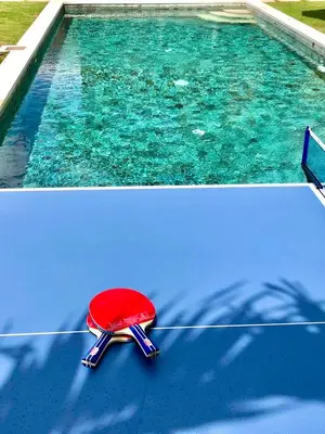 a red chair sitting on top of a swimming pool at Villa Besakih in Canggu