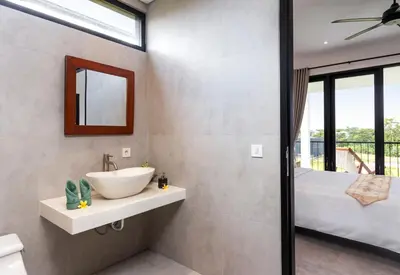 a bathroom with a sink and a mirror and a bed at Villa Sakayana 4BR Canggu in Canggu