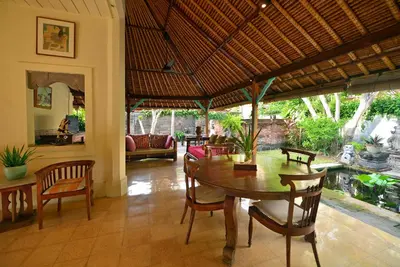 a dining room with a table and chairs at Bebek Cottages Sanur in Sanur