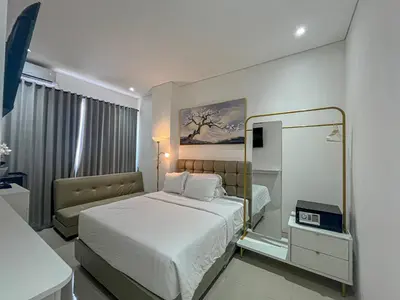 a hotel room with a bed and a mirror at Graha Socio Hotel Nusa Dua Bali in Nusa Dua
