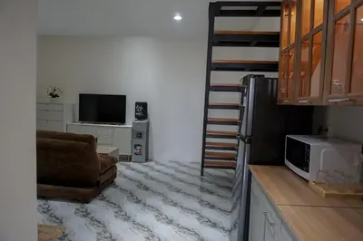 a living room with a couch and a television at Graha Socio Hotel Nusa Dua Bali in Nusa Dua
