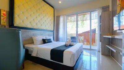 a bedroom with a bed and a large window at Graha Socio Hotel Nusa Dua Bali in Nusa Dua