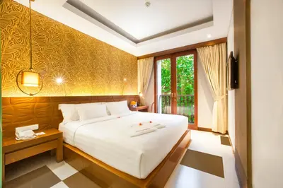 a bedroom with a large white bed and a window at Sun Island Hotel & Spa Legian in Legian