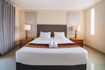 a bedroom with a large bed with two white towels on it at Villa Kinawa Seminyak in Seminyak