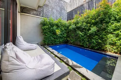 a small backyard with a pool and some plants at Villa Kinawa Seminyak in Seminyak