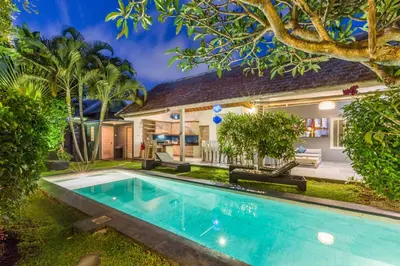 a swimming pool in front of a house at VILLA Nuri Merah 2 in Seminyak