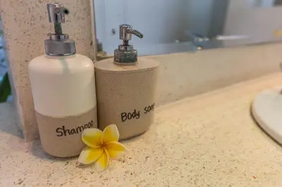 two bottles of soap and a flower on a counter at VILLA Nuri Merah 2 in Seminyak