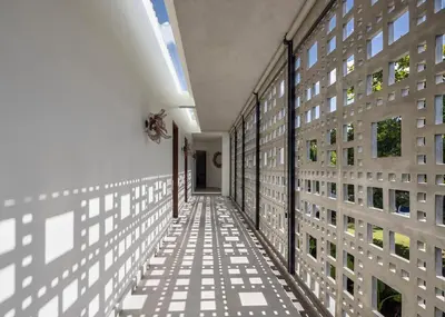 a hallway of a building with white walls and windows at La Maison d'Ulysse - Luxury 4-Bedroom Villa with Pool in Canggu in Kerobokan