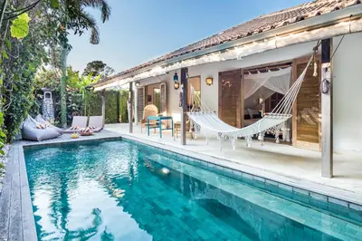 a villa with a swimming pool and a house at Villa 007 in Seminyak