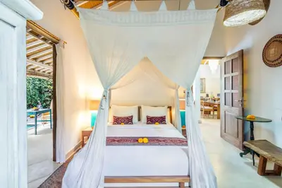 a bedroom with a bed with a canopy at Villa 007 in Seminyak
