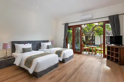 a hotel room with two beds and a balcony at Andaman Umalas by Kerta Living in Canggu