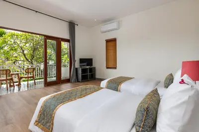 two beds in a room with a balcony at Andaman Umalas by Kerta Living in Canggu