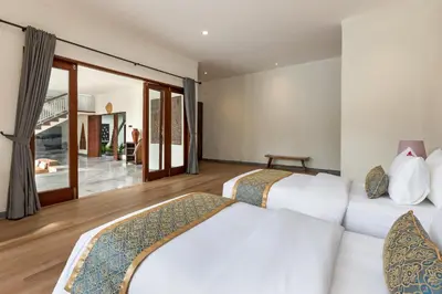 a bedroom with two beds and a living room at Andaman Umalas by Kerta Living in Canggu