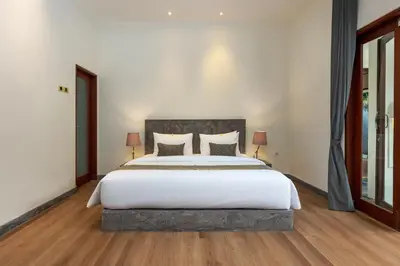 a bedroom with a large bed with white sheets at Andaman Umalas by Kerta Living in Canggu