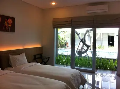 a bedroom with a bed and a sliding glass door at Mi Casa Residence in Seminyak