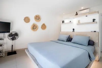 a bedroom with a blue bed and a flat screen tv at Villa Baik Baik by BaliSuperHost in Seminyak