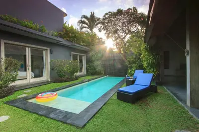 a swimming pool with a blue chair and a frisbee at Villa Jalak in Seminyak