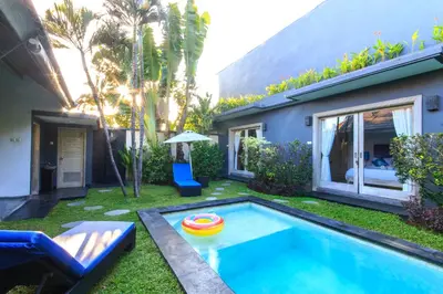 a swimming pool with a frisbee next to a house at Villa Jalak in Seminyak