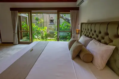 a bedroom with a large bed with pillows at Balidroomvilla Sanur - Full Serviced - Beachside in Sanur