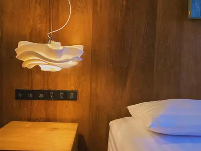 a bedroom with a bed and a light on the wall at Tekuni 2 in Legian