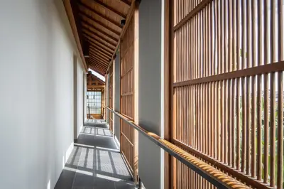 a hallway of a building with wooden windows at Tekuni 2 in Legian