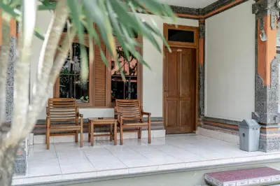 three chairs and a table on a porch at Bendesa Accommodation in Kuta