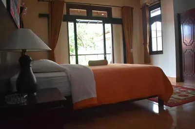 a bedroom with a bed and a large window at Bendesa Accommodation in Kuta
