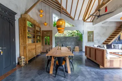 a dining room with a wooden table and chairs at Villa Palm Jari 1 by Alfred in Bali in Canggu