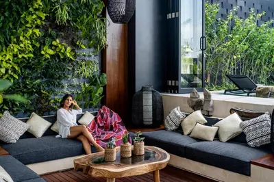 a woman sitting on a couch talking on a cell phone at Villa Australis in Kerobokan