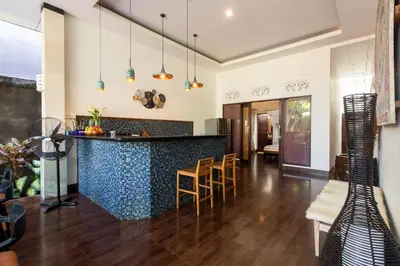 a kitchen and living room with a counter and chairs at CASA PINARAK 1 I 3BR Private Villa near Seminyak in Seminyak