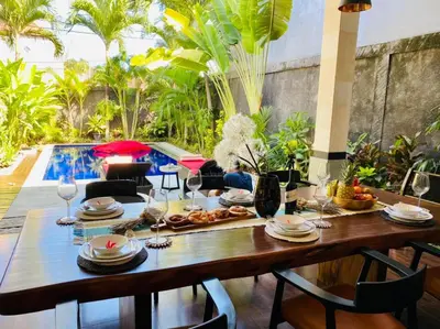 a table with plates and wine glasses on a patio at CASA PINARAK 1 I 3BR Private Villa near Seminyak in Seminyak