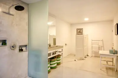 a white bathroom with a sink and a mirror at Villa Lola in Seminyak