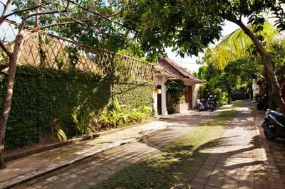 a brick road next to a fence and a building at Villa Lola in Seminyak