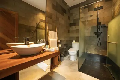 a bathroom with a sink and a toilet and a shower at Bali Karma Sajtra Hotel in Seminyak